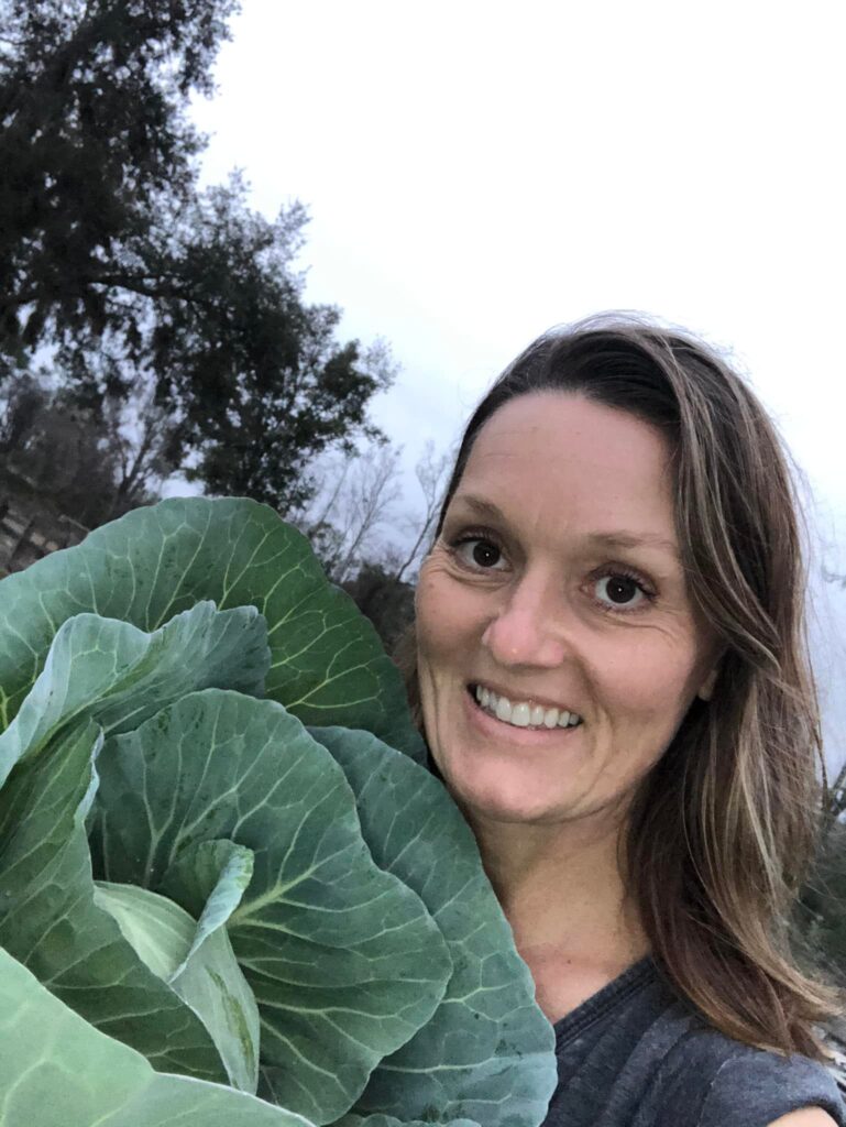 Donna Larson homesteading, holds head of cabbage