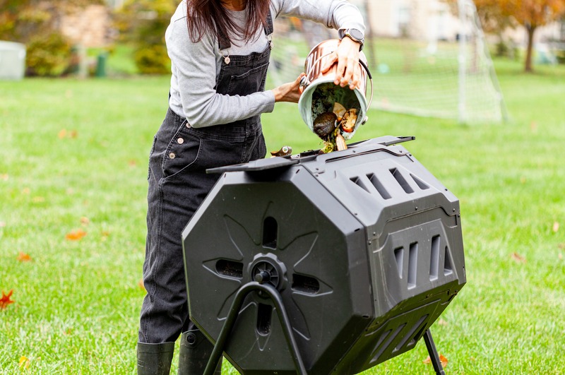 food scraps poured into compost tumbler