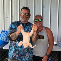 a couple holding up a processed chicken