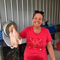a lady holding a chicken she processes