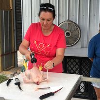a woman processing a chicken