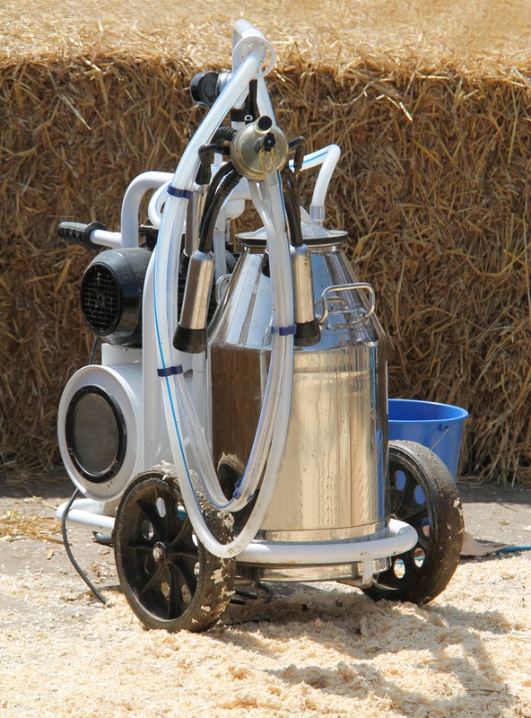 cow-milking-machine-with-hay-bales-in-background