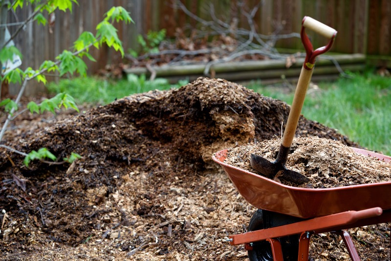 a wheel barrow full of mulch with a shovel in it