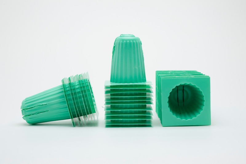 Green plastic seeding pot on white background.