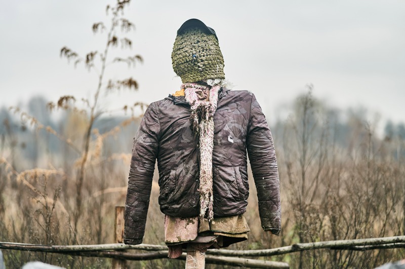 a scarecrow set on a fence post