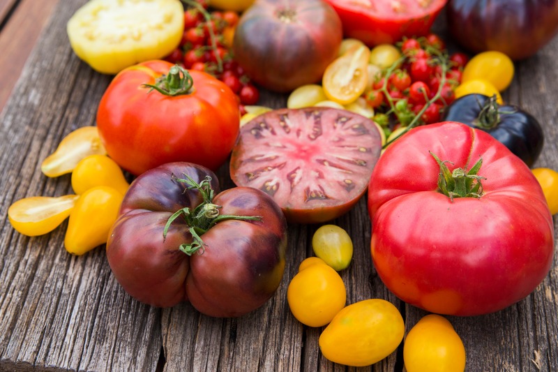 variety of heirloom tomatoes on wood table