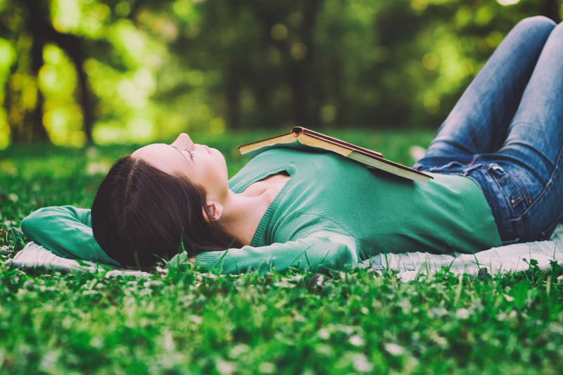 Young woman lying down in nature and sleeping,intentionally toned image.