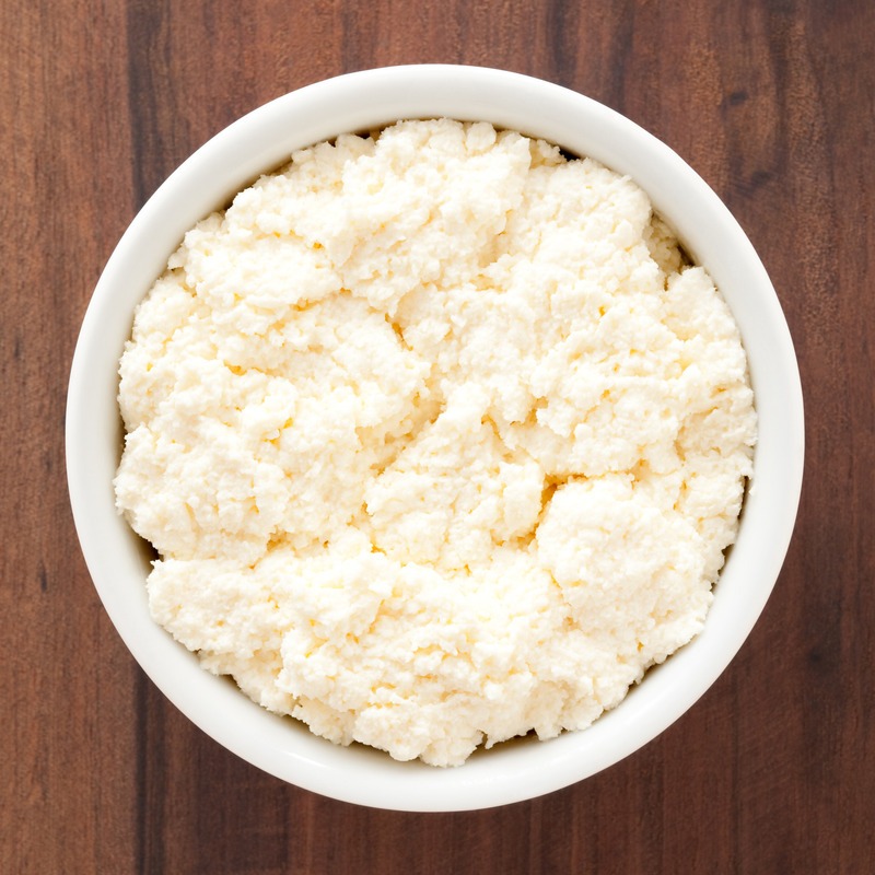 Top view of white bowl full of ricotta cheese