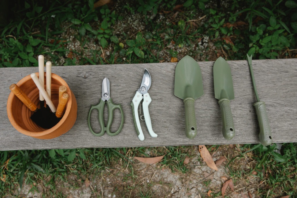 overhead view of garden tools laid out on bench
