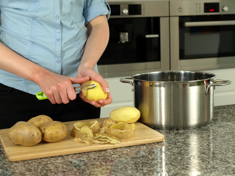 Preparing potatoes for boiling in silver pot