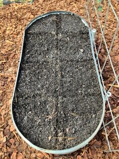 Square foot garden template marked out in the raised garden bed